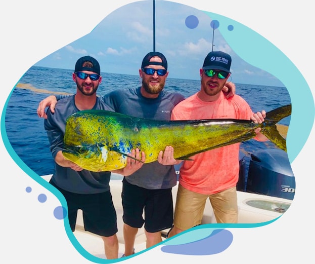 Friends holding a fish on a deep sea fishing trip in Louisiana