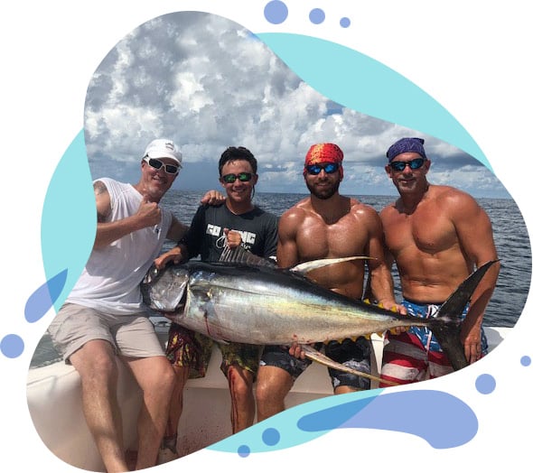Friends holding a tuna fish on fishing trip in Louisiana